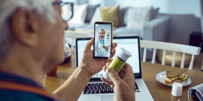 Close up of a senior man consulting with a doctor on his phone